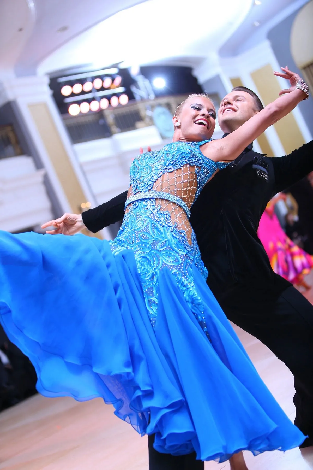 Slawek and Denise dancing a ballroom standard routine, Denise in a flowing blue gown